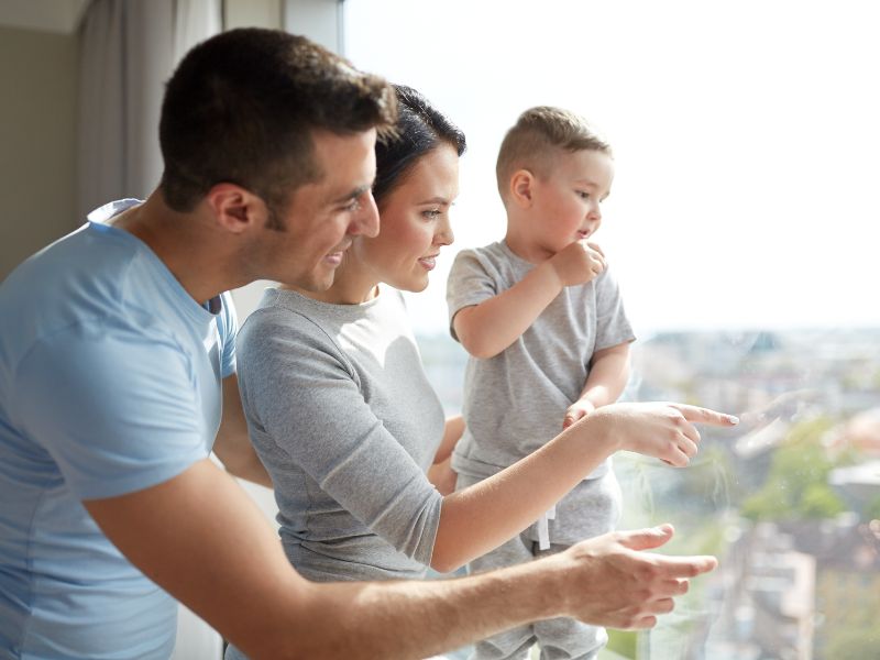 Family Standing By A Large Window